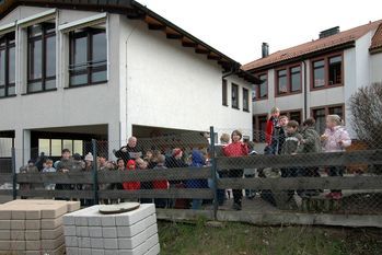 Foto: Schott: Schulleiter Heinrich Furrer erläutert den Kindern den Plan, den ein Landschaftsarchitekt ausgearbeitet hat.