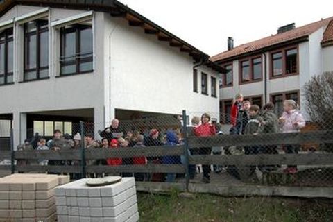 Foto: Schott: Schulleiter Heinrich Furrer erläutert den Kindern den Plan, den ein Landschaftsarchitekt ausgearbeitet hat.